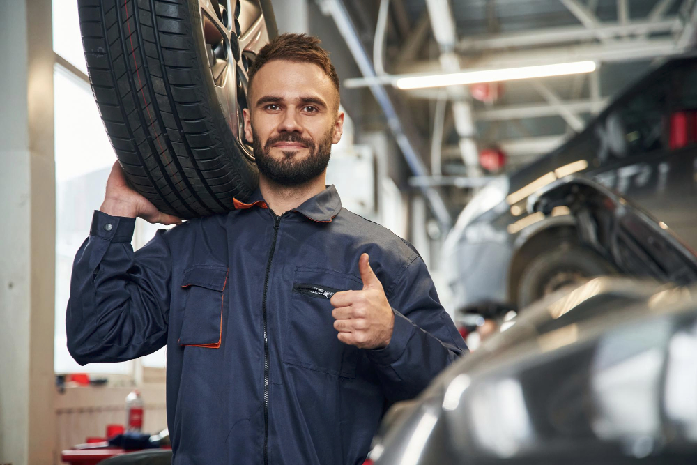 Technicien accueillant un client dans un atelier de carrosserie moderne