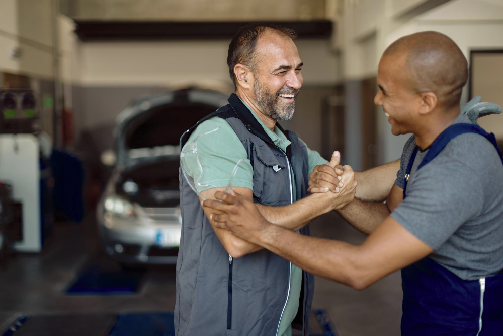 Carrossiers professionnels heureux avec un client satisfait